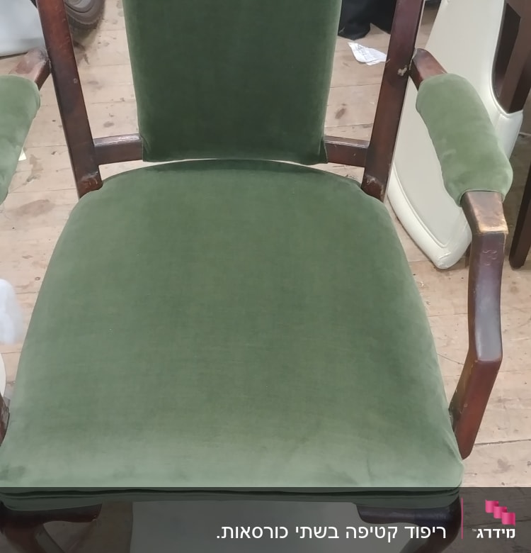 כיסא מרופד בבד ירוק עם מסגרת עץ כהה